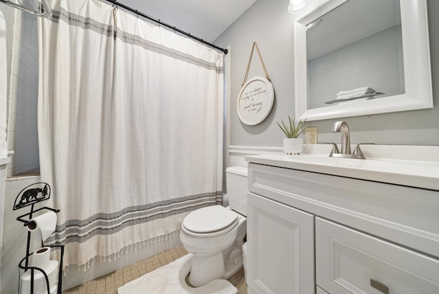 full bath with a shower with curtain, vanity, wainscoting, and toilet