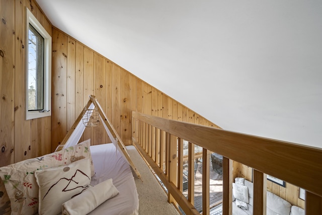 bonus room featuring wood walls