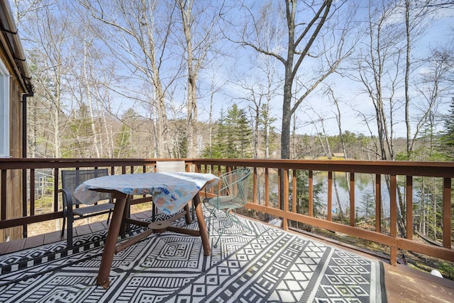 deck featuring outdoor dining space and a water view