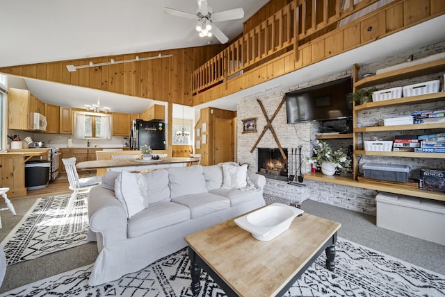 living area with a brick fireplace, a ceiling fan, high vaulted ceiling, and light colored carpet