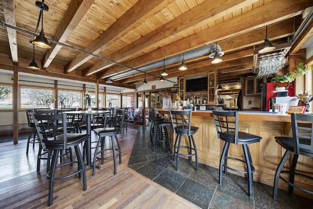 bar with a healthy amount of sunlight, wood ceiling, a community bar, and beam ceiling