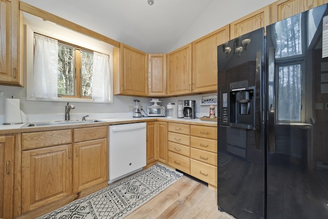 kitchen with black fridge with ice dispenser, white dishwasher, a sink, and light brown cabinets