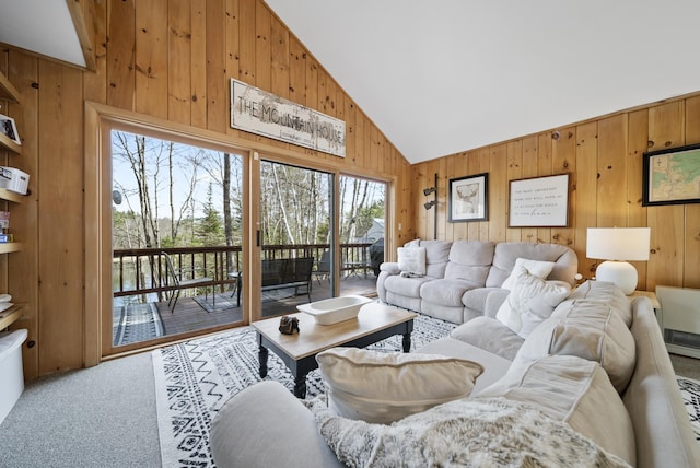 living area featuring carpet floors, wooden walls, and high vaulted ceiling