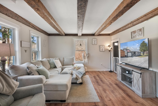 living room with baseboards, light wood-style floors, and beam ceiling