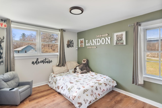 bedroom with baseboards and wood finished floors