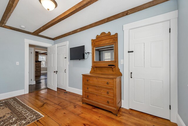 104 Pease Rd, Meredith, NH 03253 - bedroom with baseboards, wood-type flooring, and beamed ceiling
