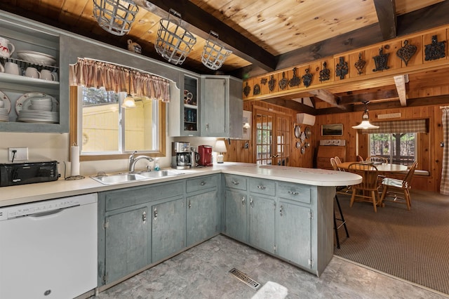 kitchen featuring visible vents, white dishwasher, black microwave, a sink, and a peninsula