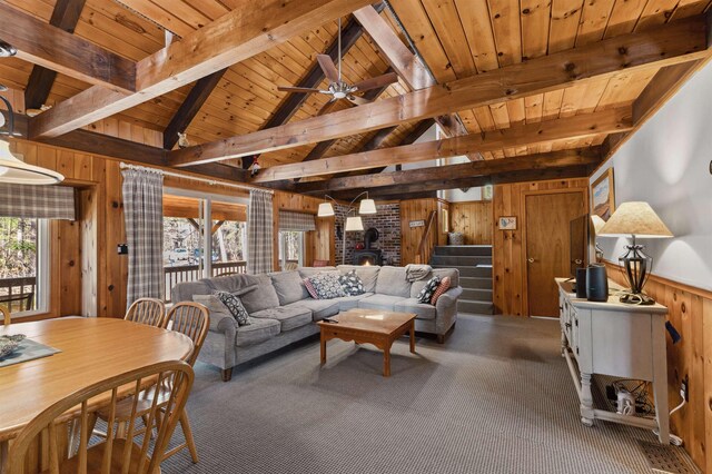 living room featuring wood ceiling, vaulted ceiling with beams, carpet flooring, and wood walls