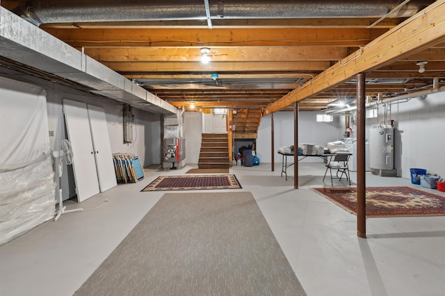 basement with heating unit, stairway, and electric water heater