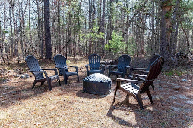 view of yard with a wooded view and an outdoor fire pit