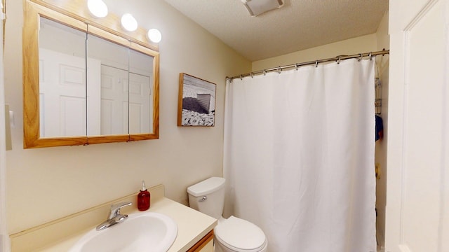 bathroom with toilet, a textured ceiling, curtained shower, and vanity