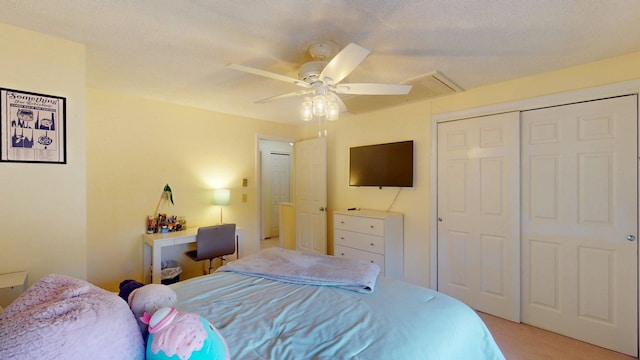 bedroom with light colored carpet, attic access, ceiling fan, and a closet