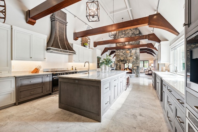 kitchen with decorative backsplash, beamed ceiling, high vaulted ceiling, a sink, and high end range