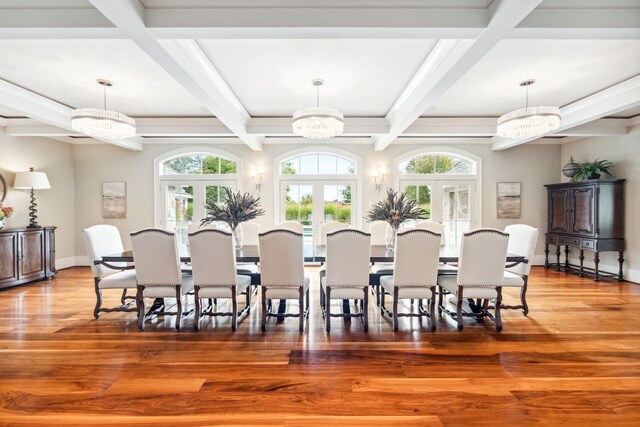 dining room with beam ceiling, a notable chandelier, plenty of natural light, and french doors