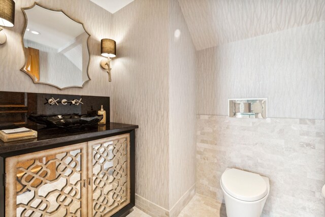 bathroom with toilet and wallpapered walls