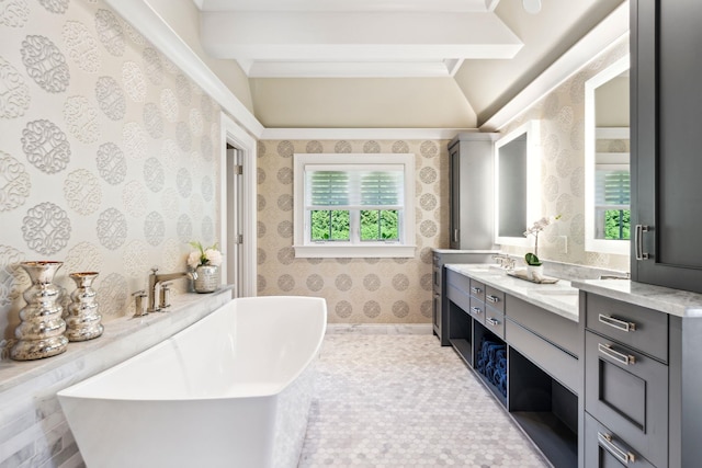 bathroom with beamed ceiling, wallpapered walls, a soaking tub, and vanity