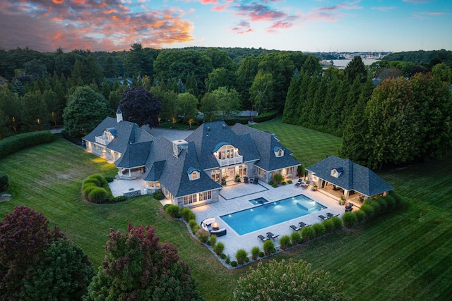 aerial view at dusk featuring a view of trees