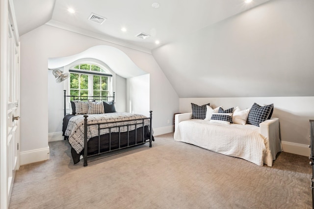 bedroom featuring visible vents, light carpet, and lofted ceiling