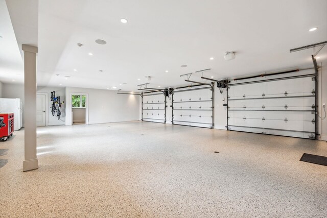 garage featuring freestanding refrigerator and recessed lighting