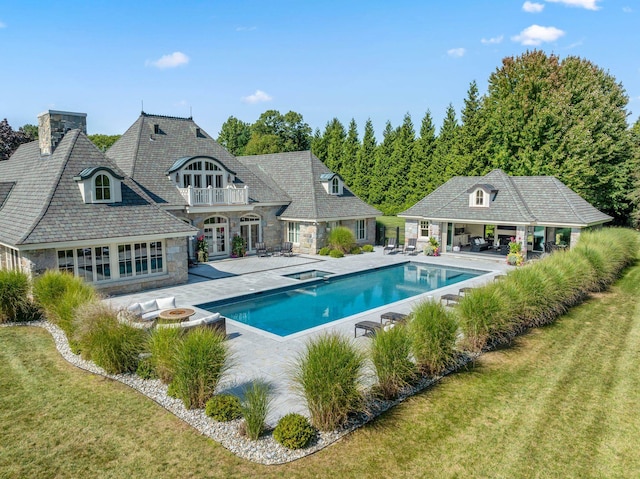 view of swimming pool featuring french doors, a patio area, an exterior structure, an outdoor structure, and an outdoor fire pit