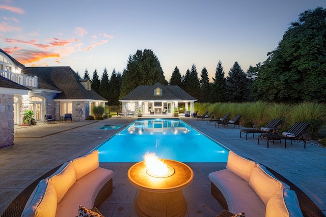 outdoor pool with an outdoor hangout area, an outdoor structure, an exterior structure, and a patio area