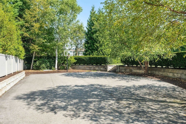 exterior space with fence and basketball hoop