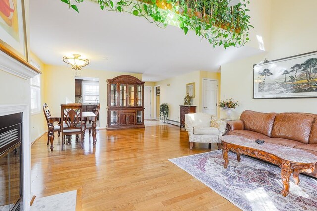living area featuring light wood-style floors, baseboards, and a notable chandelier