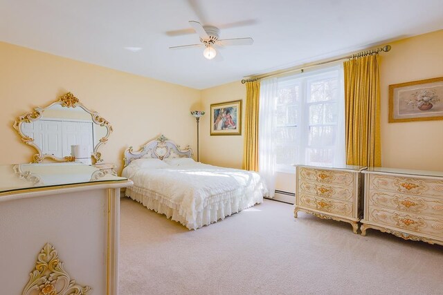 carpeted bedroom with a ceiling fan and baseboard heating