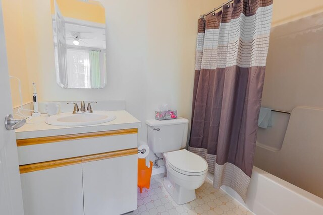 full bath featuring toilet, a ceiling fan, shower / bath combo with shower curtain, and vanity