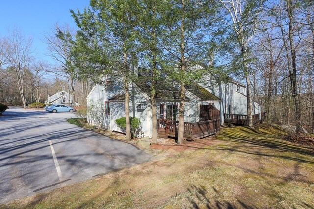 view of home's exterior with driveway and a deck