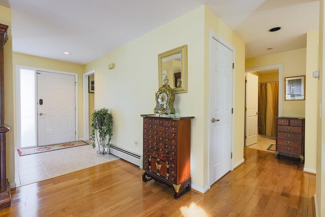 foyer featuring recessed lighting, baseboards, a baseboard heating unit, and wood finished floors
