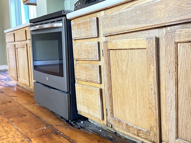 interior details with light brown cabinets and electric range
