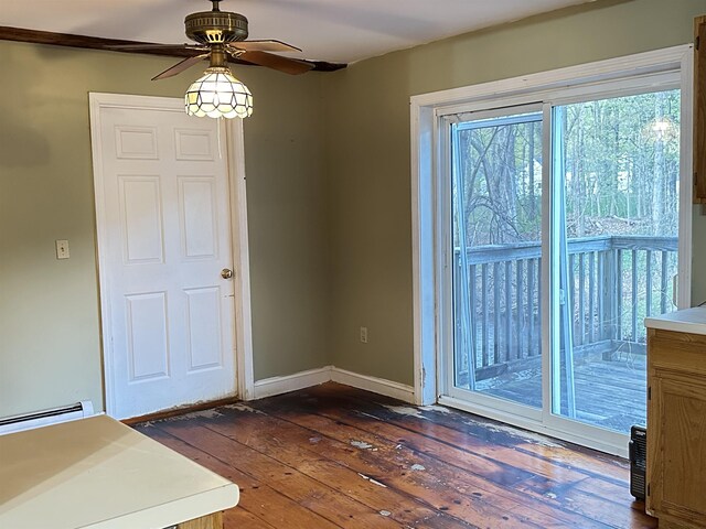 interior space with baseboards, a ceiling fan, dark wood-style floors, and a baseboard heating unit