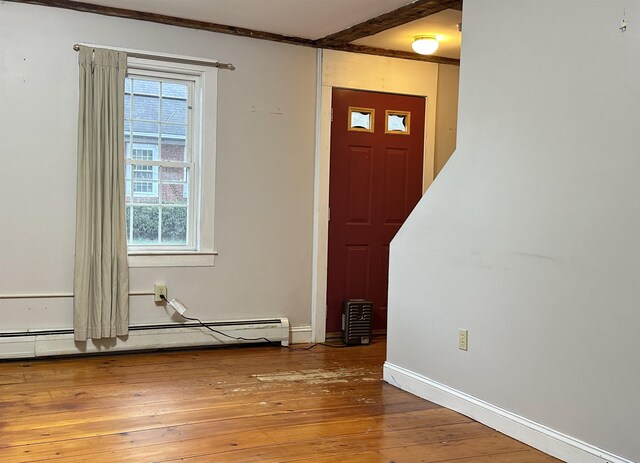 foyer entrance with baseboards, a baseboard radiator, hardwood / wood-style flooring, and a wealth of natural light