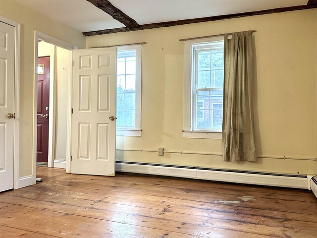 interior space featuring a baseboard heating unit and hardwood / wood-style floors