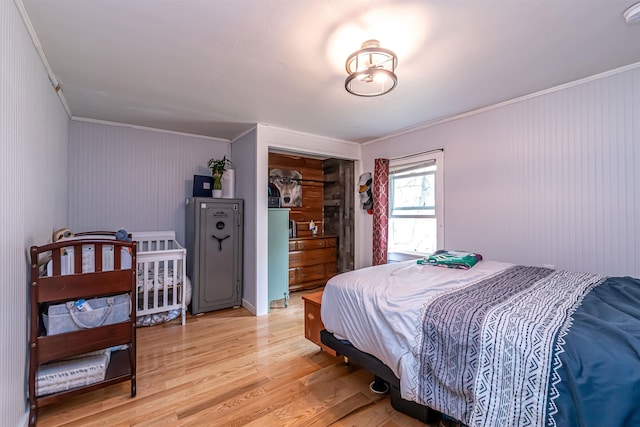 bedroom with ornamental molding, a closet, and light wood-style flooring
