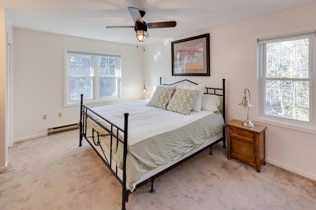 bedroom with baseboards, baseboard heating, and light carpet