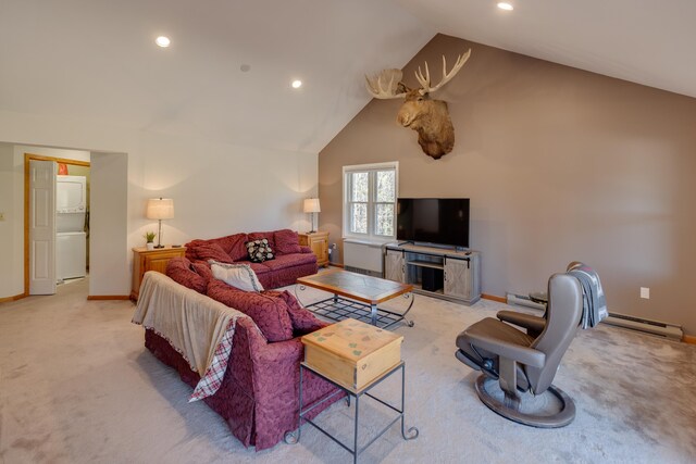 living room with stacked washer / dryer, light colored carpet, vaulted ceiling, baseboards, and a baseboard heating unit