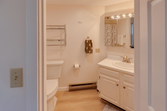 full bath featuring vanity, toilet, baseboards, wood finished floors, and a baseboard heating unit