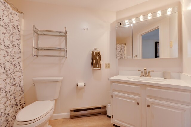 bathroom featuring curtained shower, vanity, a baseboard radiator, baseboards, and toilet