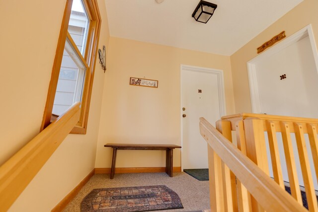 corridor with carpet floors and baseboards