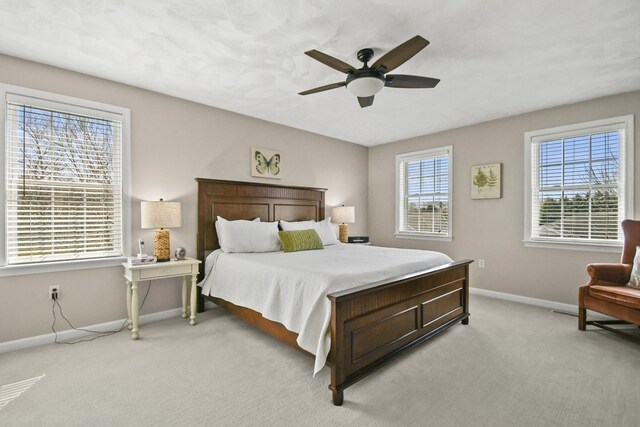 bedroom featuring a ceiling fan, baseboards, and light carpet