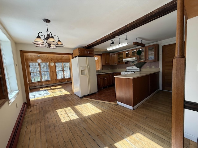 kitchen with a sink, white appliances, a peninsula, a baseboard heating unit, and glass insert cabinets