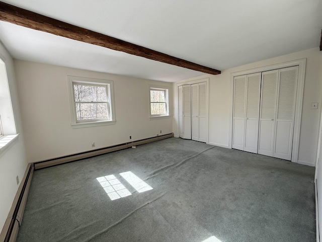unfurnished bedroom with two closets, a baseboard heating unit, carpet, and a baseboard radiator