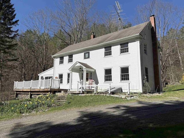 colonial-style house with a chimney and a deck