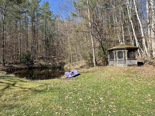 view of yard featuring a gazebo and a forest view