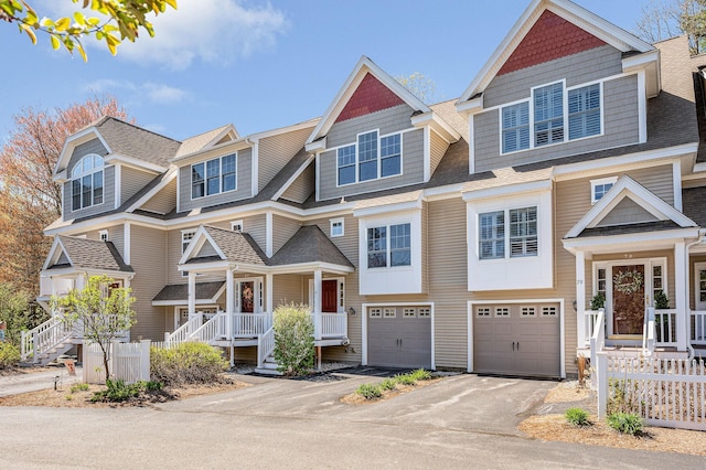 view of front of home featuring fence, a shingled roof, an attached garage, and driveway