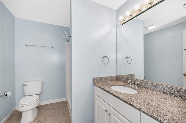 full bathroom with toilet, baseboards, tile patterned flooring, and vanity