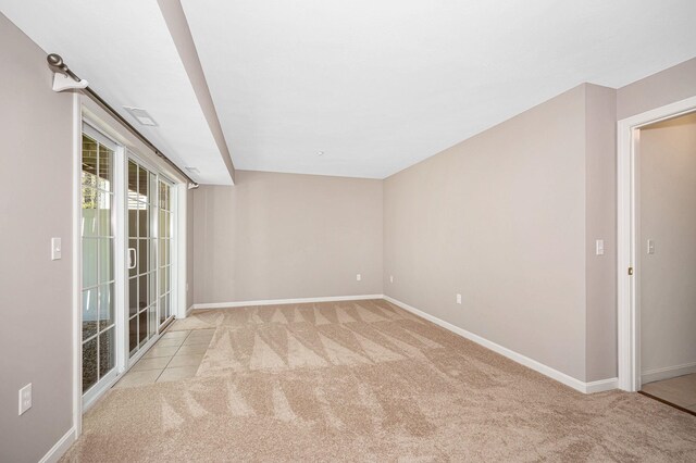 spare room featuring baseboards and light carpet
