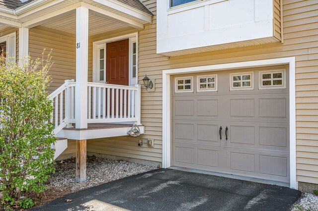 doorway to property with a garage and aphalt driveway